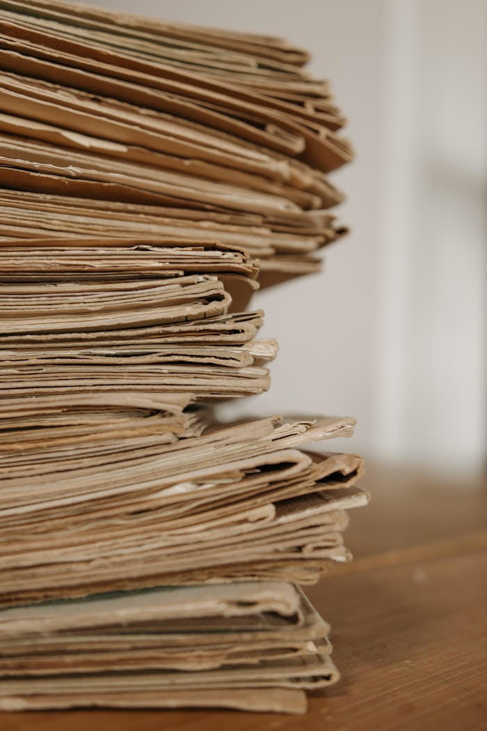 Close-up of vintage paper stacks on a wooden table, evoking a classic office setting.